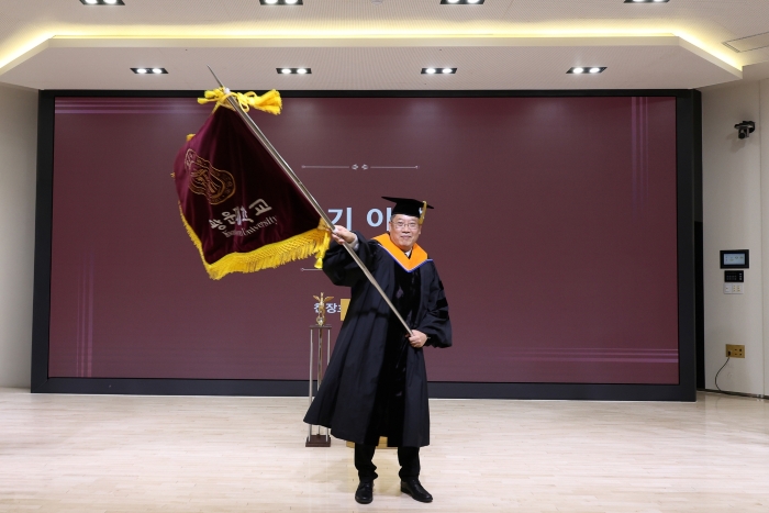 교기를 이양받아 힘차게 흔들고 있는 모습 